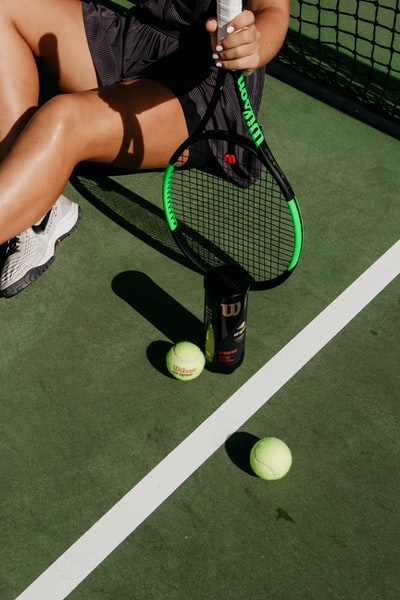 坐在球旁边拿着网球拍的女人